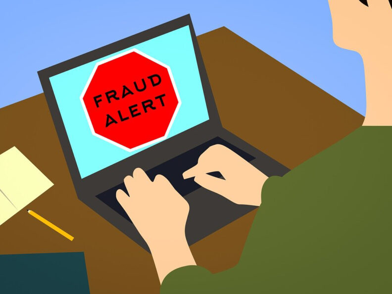 Illustration of a person using a laptop that has a large red stop sign on it with the word fraud.
