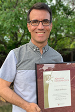 A smiling man holding a certificate.