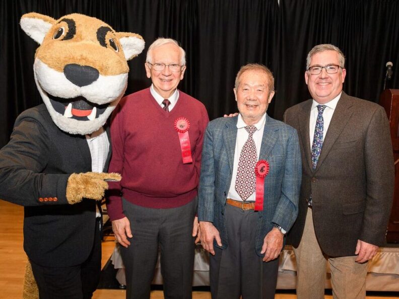 Three people standing next to the WSU Cougar mascot..