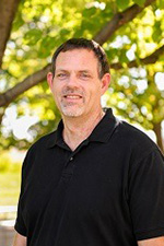 A smiling man standing outside.