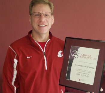 A smiling man in a WSU shirt holding a certificate.