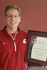 A smiling man holding a certificate.