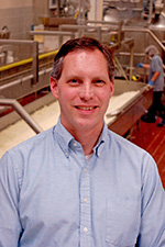 A smiling man in a blue shirt.