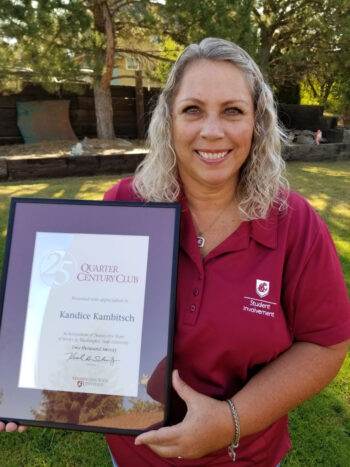 A smiling woman in a WSU shirt holding a certificate.