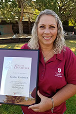 A smiling woman holding a certificate.