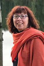 A smiling woman in a red coat.