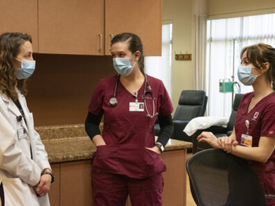 A nursing professor talks with two students.
