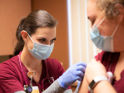 A nursing student gives a COVID-19 vaccine.