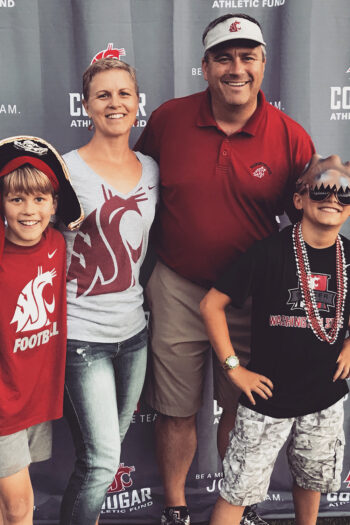 Two adults and two children all wearing WSU Cougar shirts.