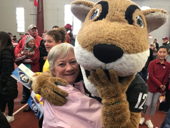 A woman hugging the WSU mascot.